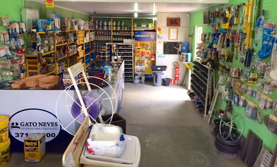 Interior da loja Gato Neves com prateleiras organizadas de ferramentas, tintas e materiais hidráulicos